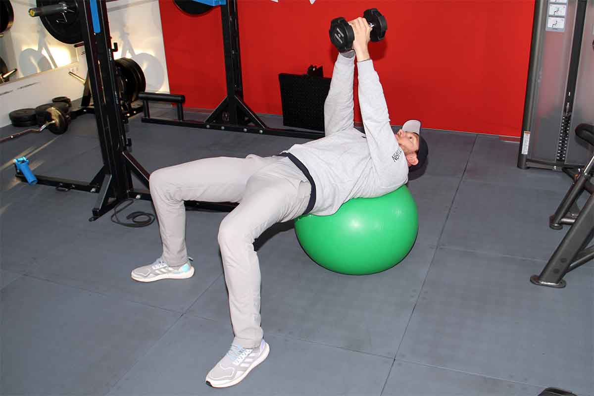 Mit dieser Rotations-Übung kräftigen Sie Ihren gesamten Körper. Legen Sie Ihren oberen Rücken auf einen Gymnastikball und bilden Sie zwischen Unterschenkel und Körper einen 90-Grad-Winkel ...